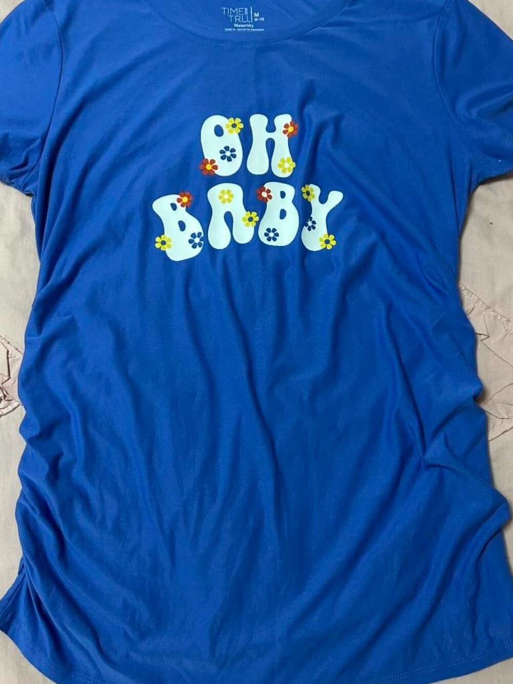 Blue “OH BABY” floral graphic maternity top.